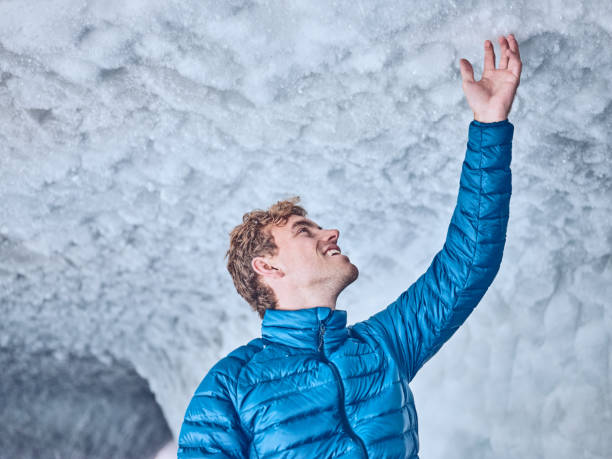 istock Young man hikes through majestic ice cave, in glacier 1341656666