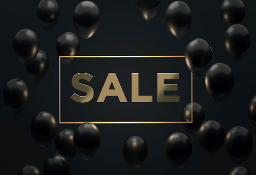 Gold sale text sitting in the midst of black balloons over black background. Horizontal composition with copy space. Front view. Great use for sale concepts.