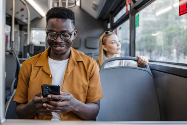 istock Young man uses mobile phone in public bus 1341658105