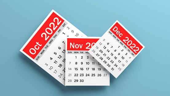 Red-and-white-colored October, November, December 2022 calendar pages. On the blue-colored background. Horizontal composition with copy space. Isolated with clipping path.