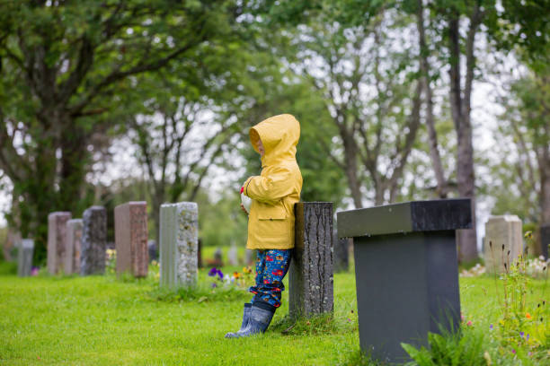 슬픈 어린 아이, 금발 의 소년, 묘지에 비에 서, 슬픈 사람, 애도 - cemetery child mourner death 뉴스 사진 이미지