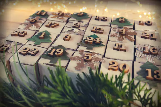 Homemade advent calendar made of cardboard for a environmentally conscious christmas. Close-up with lying cubes and short depth of field.