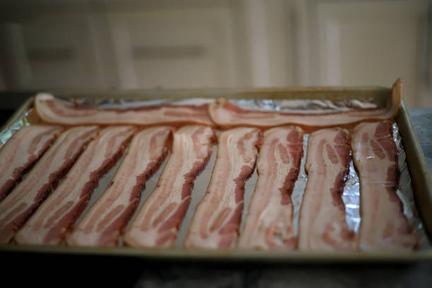 istock Strips of bacon sitting on a tray to be cooked 1341662789