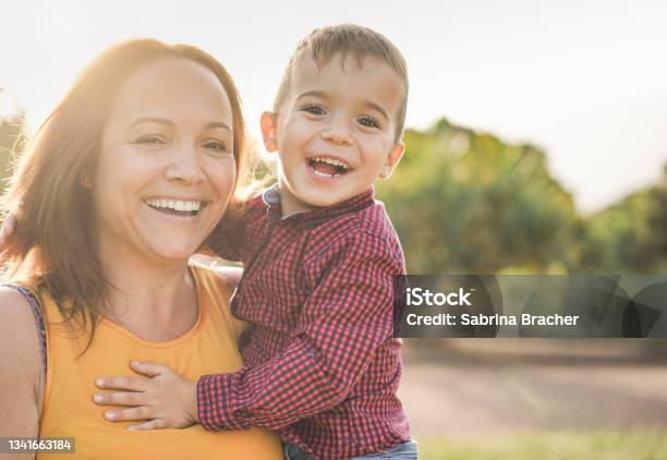 Happy Latin Mother Holding Son In Her Arms And Laughing On Camera Mother And Child Love Stock Photo - Download Image Now