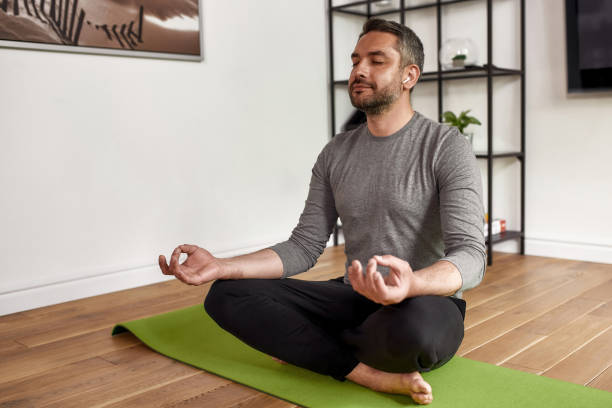 istock Middle-aged Caucasian man meditate practice yoga at home 1341663404
