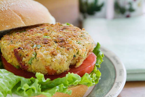 Close-up of a veggie burger with lettuce and tomatoes stock photo