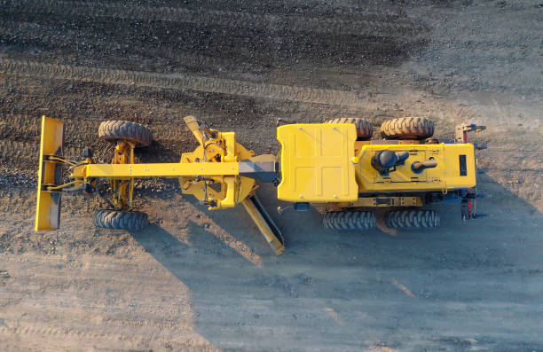 Grader Road Construction Grader industrial machine on construction of new roads. the blade of a motor grader in the process of leveling a sandy road foundation. Grader is working on road construction. stock photo