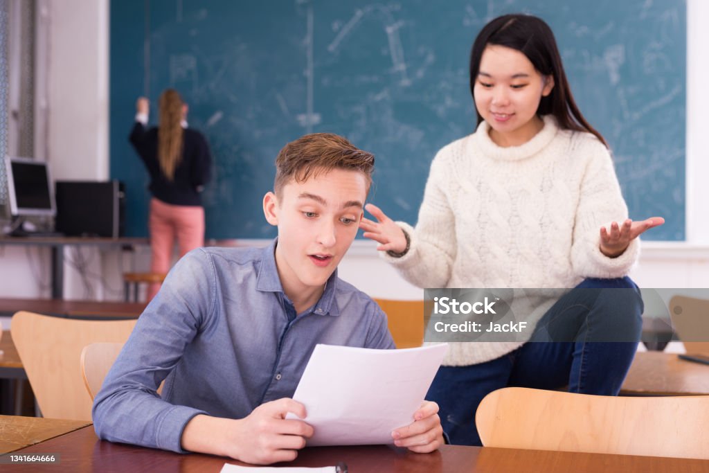 Delighted Teenager And Chinese Girl Schoolmate Reading Notification Stock Photo Download Image Delighted Teenager And Chinese Girl Schoolmate Reading Notification Stock Photo Download Image