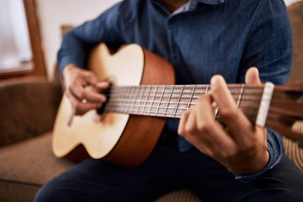 istock Shot of a man practicing his guitar skills at home 1341667176