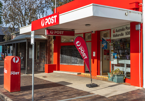 Adelaide, Australia - May 5, 2021: Walkerville 5081 Post Office, Walkerville Tce: very bright red facade,  three-quarter front view (right) showing Australia Post signage, secure private mail boxes, posting box and advertising banner, \
