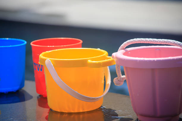 a picture of Colorful buckets filled with water by a pool