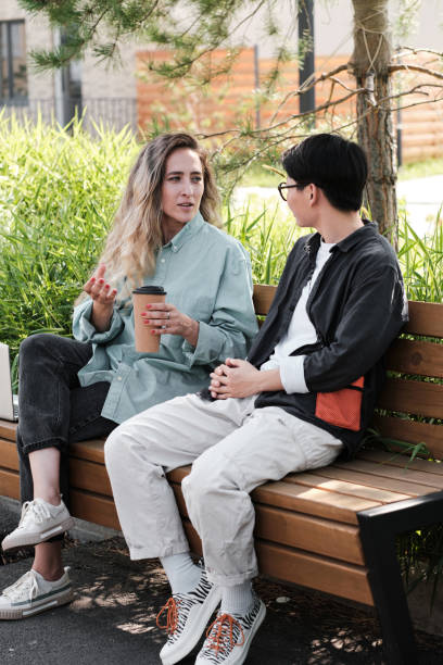 istock Two Young Women Sitting On Bench 1341670257