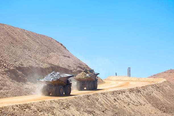 Huge dump trucks Huge dump trucks loaded with mineral  in a copper mine in Chile. copper mine stock pictures, royalty-free photos & images