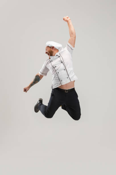 istock One Caucasian bearded man, chef in uniform jumping high isolated on white background. Concept of job, occupation, humor. 1341676276