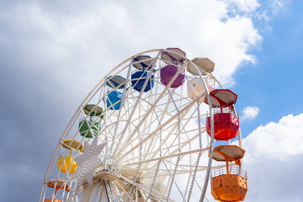istock Colorful ferris wheel on a shiny day with some clouds in the background 1341676647