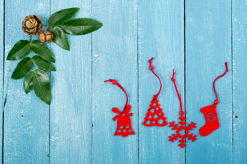 classic red felt Christmas ornaments on blue wood table background