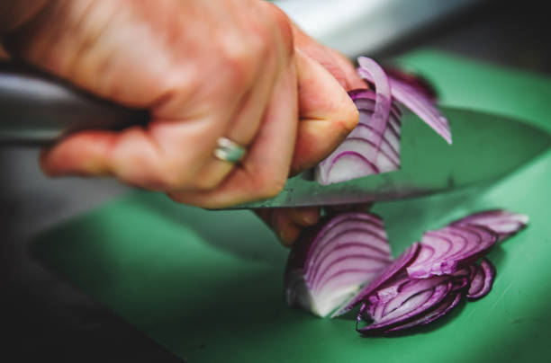 istock Chefs man hands chopping onion on board 1341676891