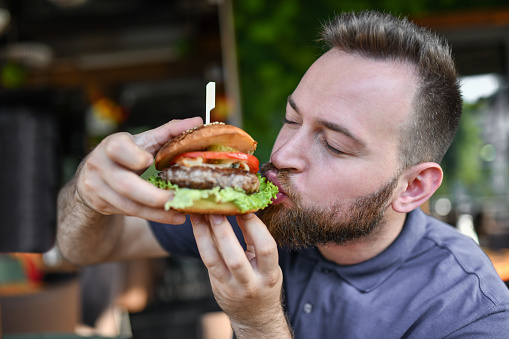 Hungry Male Eating Delicious Burger