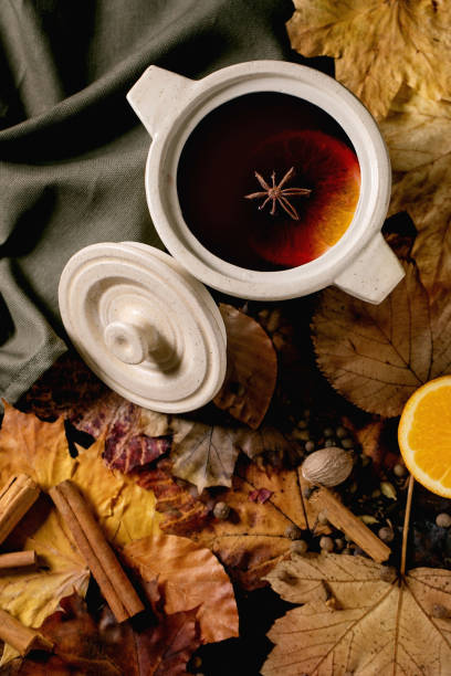 istock Hot mulled wine with spices and autumn leaves 1341679450