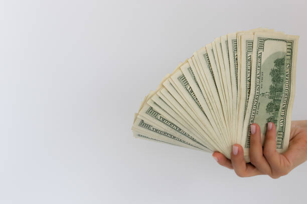 istock Female hand holding USA dollars. On a white background with a copy space. 1341679459