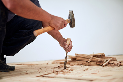 Repairman restoring old parquet hardwood floor.