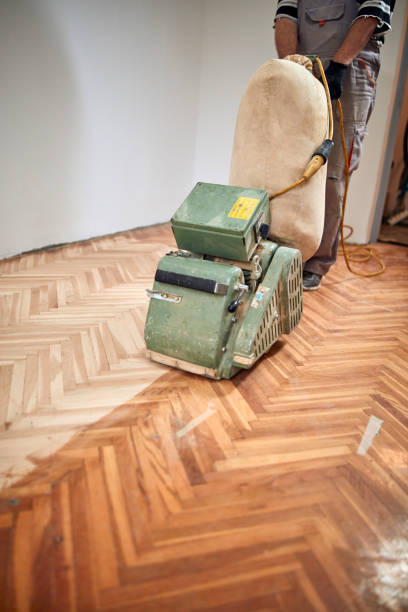 istock Repairman restoring parquet with a sanding machine. 1341683745
