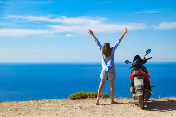 istock Woman with scooter looking at the distant sea horizon. 1341684586