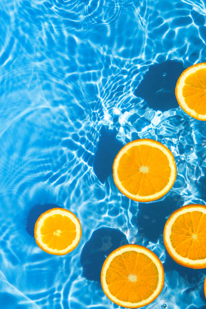 istock Creative summer composition made of sliced orange in transparent pool water. Refreshment concept. Healthy refreshing drink theme. Top view 1341684963