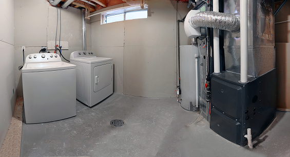 A home laundry room with a dryer, washer, a high efficiency furnace with a residential gas water heater & an humidifier.