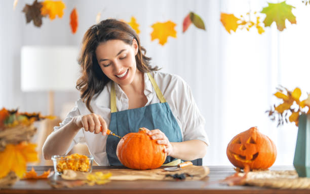 istock woman is carving pumpkin 1341686645
