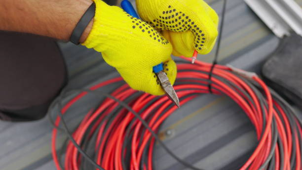 istock Electrician technician worker with wire stripper plier prepares the electric cable in electrical system. Electrician installing wires. A professional electrician removes electrical insulation 1341686700