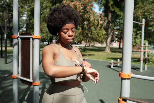 istock Young sportswoman pointing at smartwatch during training 1341688142