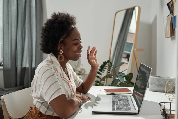 istock Young employee waving hand to someone on laptop screen 1341688187