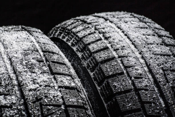 istock Winter Car tires with snow close-up wheel profile structure on black background 1341688967