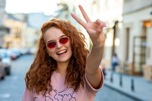 Pretty woman in glasses showing victory gesture