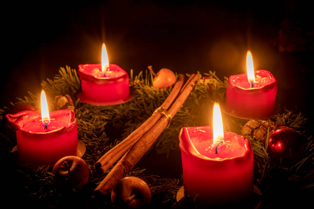istock Decorated advent wreath made of fir branches with burning red candles 1341692016