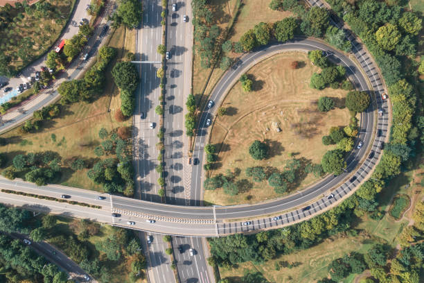 istock Cars drive along loop shaped road junction top view. 1341693624