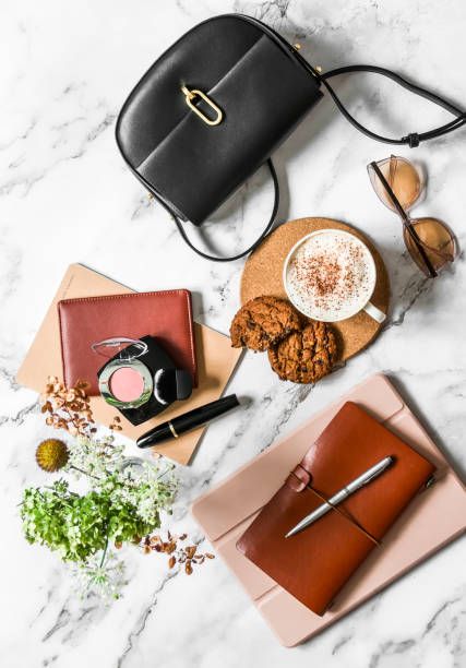 istock Women's office desk - notebooks, organizer, tablet, cappuccino cup and cookies with chocolate drops on a marble background, top view 1341693894