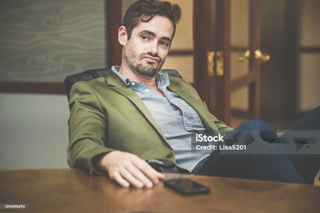 Cocksure businessman in an office confident and cool attitude Man with overly confident attitude in casual business wear Arrogance Stock Photo