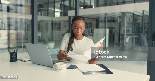 Shot Of A Beautiful Young Woman Doing Some Paperwork In A Modern Office Stock Photo - Download Image Now
