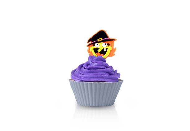 Cupcake with purple cream in grey form with witch decor isolated on a white background Cupcake with purple cream in grey form with witch decor isolated on a white background. halloween cupcake stock pictures, royalty-free photos & images