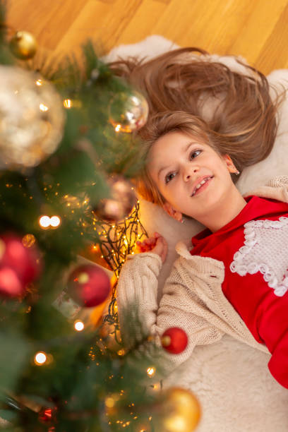 istock Little girl lying under a Christmas tree 1341697130