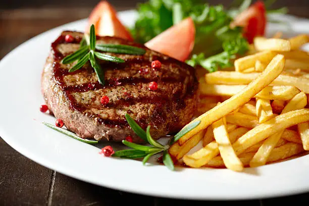 grilled beefsteak with french fries and rosemary
