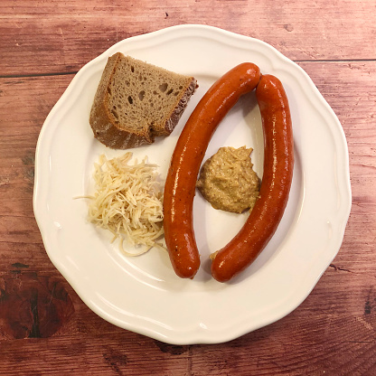 Debrecen or Debreziner sausage with mustard, fresh horseradish and slice of bread.