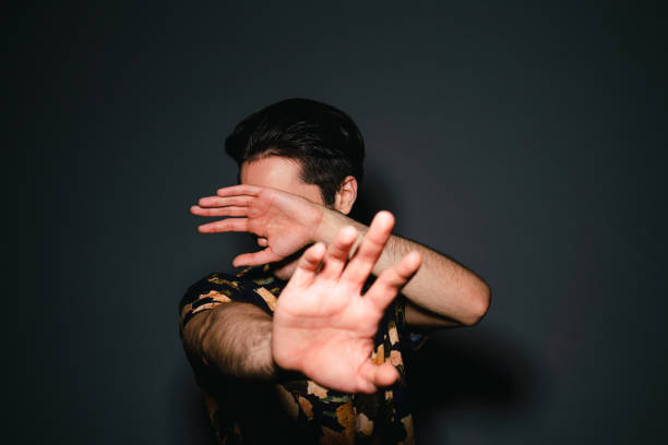 Vip person is protecting himself from the paparazzi. He's cover his face with the hands.