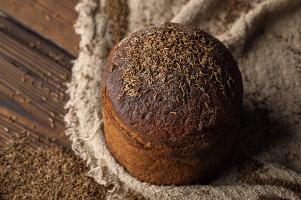 istock Round loaf of rye bread with thyme on rustic style wooden table 1341700692