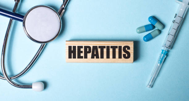 hepatitis ditulis di blok kayu dekat stetoskop, jarum suntik dan pil dengan latar belakang biru. konsep medis - hepatitis potret stok, foto, & gambar bebas royalti
