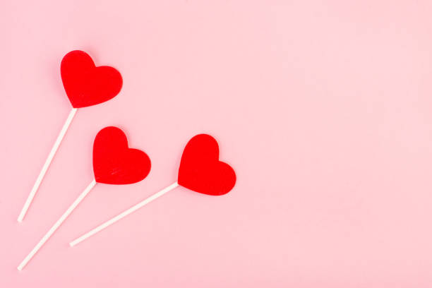 istock red hearts on a stick top view on pink background, Valentine's day background 1341704838