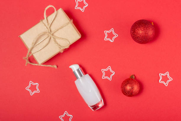 istock Cosmetic jar and Christmas decorations and gift on a red background. 1341704953