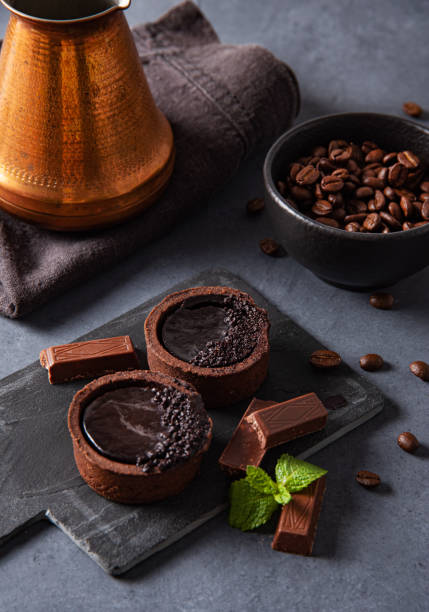 istock mini chocolate tarts with coffee beans on a dark background. Close up